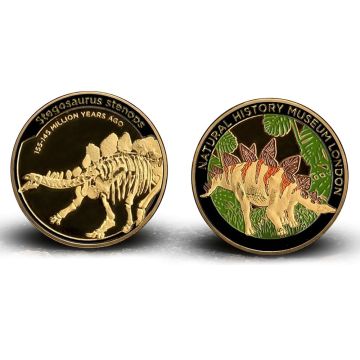 Both sides of the medal are shown. On the left is the skeleton of Stegosaurus stenops and on the right is a coloured depiction of it next to jungle-like palm leaves.