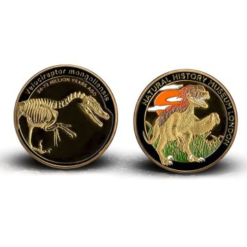 Both sides of the medal are shown. On the left is the skeleton of Velociraptor mongoliensis and on the right is a coloured depiction of it on the grassland.