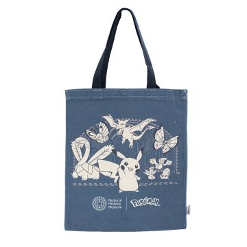The navy-blue tote bag has a graphic in cream on the side. It’s of Pikachu surrounded by Tropius, Butterfree, Aerodactyl, Vivillon, Archen, Oddish and Omanyte in the Museum’s Hintze Hall. The handles are black.