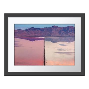  The Great Divide Wall Print in a grey frame. An aerial view of the Great Salt Lake, Utah, divided by an industrial ledge, with pink water on the left and white water on the right.