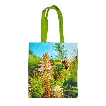 One side of the tote bag shows a colour image of bumblebee mid-flight among flowers in a sunny English garden. 
