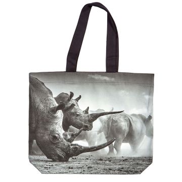 One side of the tote bag shows a black and white image of white rhinos with long horns grazing on the dusty ground. The handles are black.
