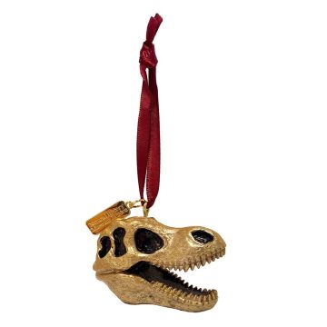 The gold-coloured T. rex skull decoration hangs on a red ribbon. There is a tag on it which says 'Natural History Museum London'.
