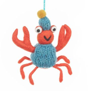 The orange snow crab dangles as if standing on its six legs and holding up its two pincers. It wears a blue jumper and bobble hat.