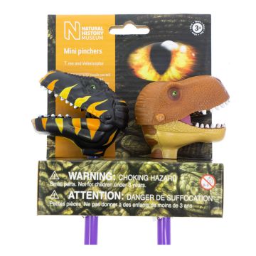 One pincher is a black-and-yellow-striped Velociraptor head, the other is a brown T. rex head, the jaws of which are moved by the pinchers at the bottom of the purple poles. The packaging has a large yellow eye.