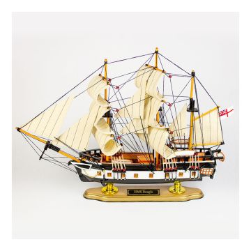 The port side of the model with the bow facing left. The white sails are curved as if being blown and the black rigging surrounds the structure. The hull has horizontal black and white stripes. The Royal Navy ensign is at the rear.