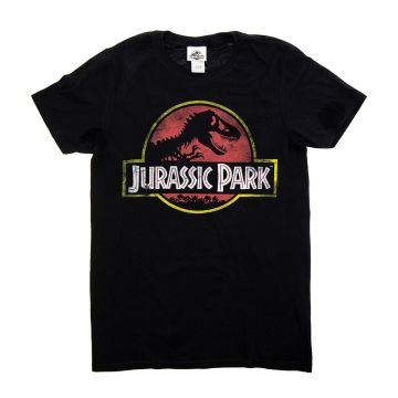 The black t-shirt is spread out on a white background. It features the Jurassic Park logo on the chest. The logo is a black skeleton of T. rex against a red sky, above the words 'Jurassic Park' in white font.