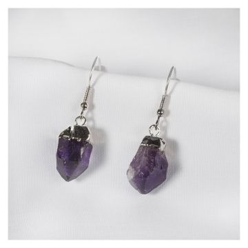 The pair of earrings are shown displayed on white cloth. The amethyst stones are a similar size but different shapes and slightly different shades of dark purple. The tops are silver plated and attached to the hook.
