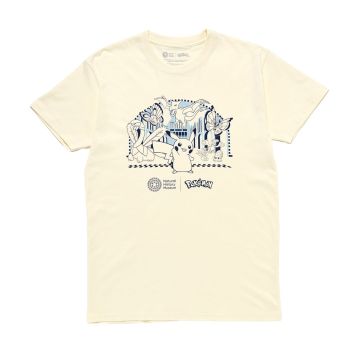 The cream t-shirt has a blue graphic on the chest. It’s of Pikachu surrounded by Tropius, Butterfree, Aerodactyl, Vivillon, Archen, Oddish and Omanyte in the Museum’s Hintze Hall.