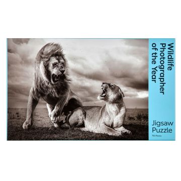 The front cover of the jigsaw box is a black and white image of two lions roaring at each other on the Namiri Plains of Tanzania’s Serengeti National Park as storm clouds gather overhead.