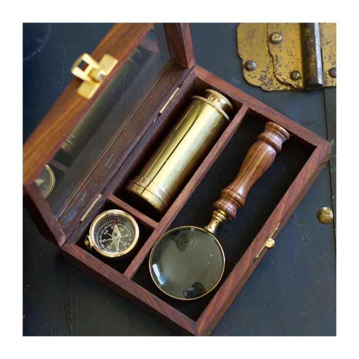 A close-up, overhead shot of the Charles Darwin Explorer Set, styled on an antique-style travel trunk.