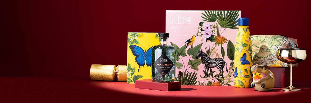 Notebooks, a calendar, a washbag, gin, Tubbz duck and water bottle against a dark red background