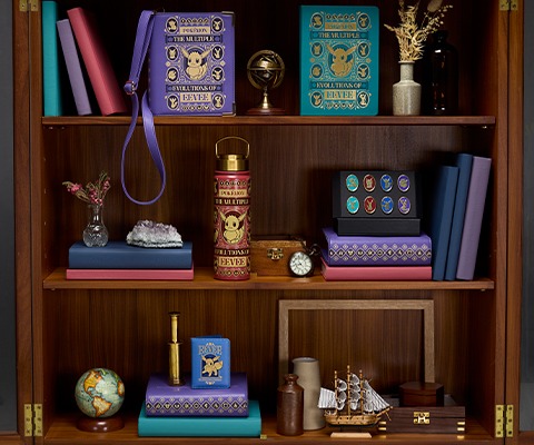 The Charles Darwin Soft Toy is styled sitting on nature-related books that have been shaped into a chair.